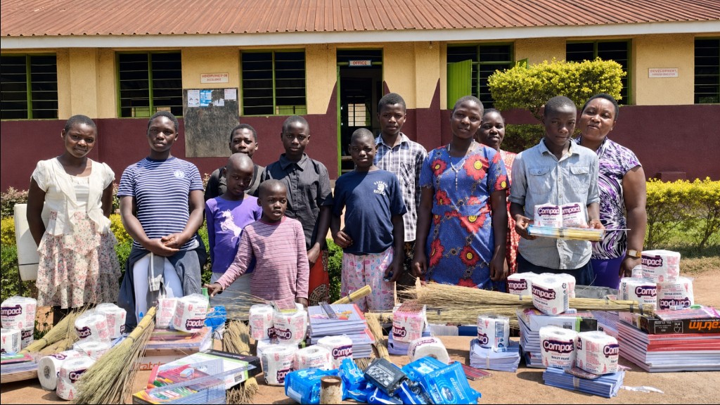 Children and community members with school supplies from Habibi Foundation Uganda